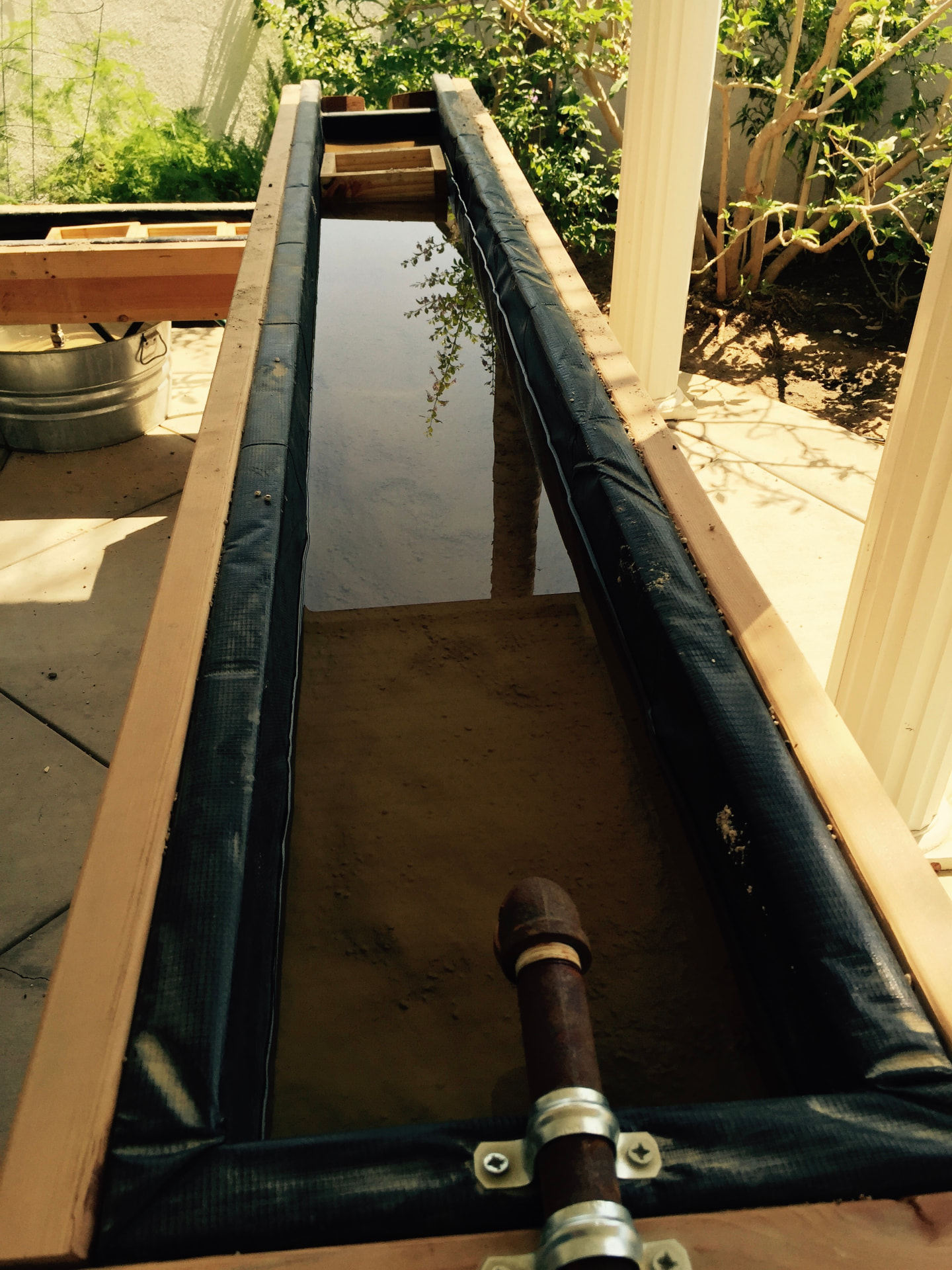 The original homemade backyard mining trough that started Kolt Mining, water running through a wooden sluice